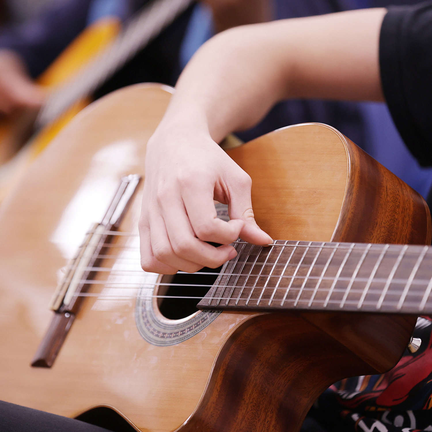 A close up of a young person playing classical guitar.