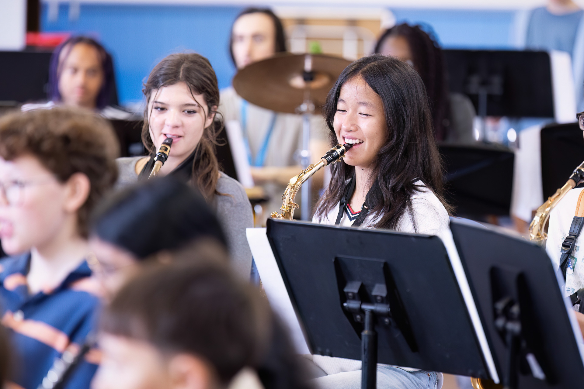 Concert Band rehearsal with two smiling saxophone players.