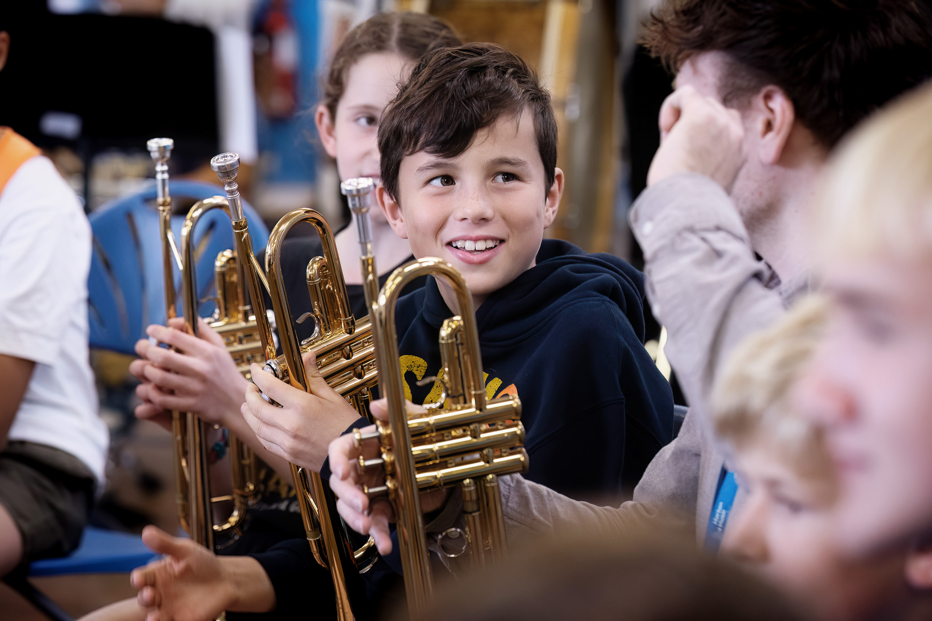 Smiling boy holding a trumpet during a band rehearsal