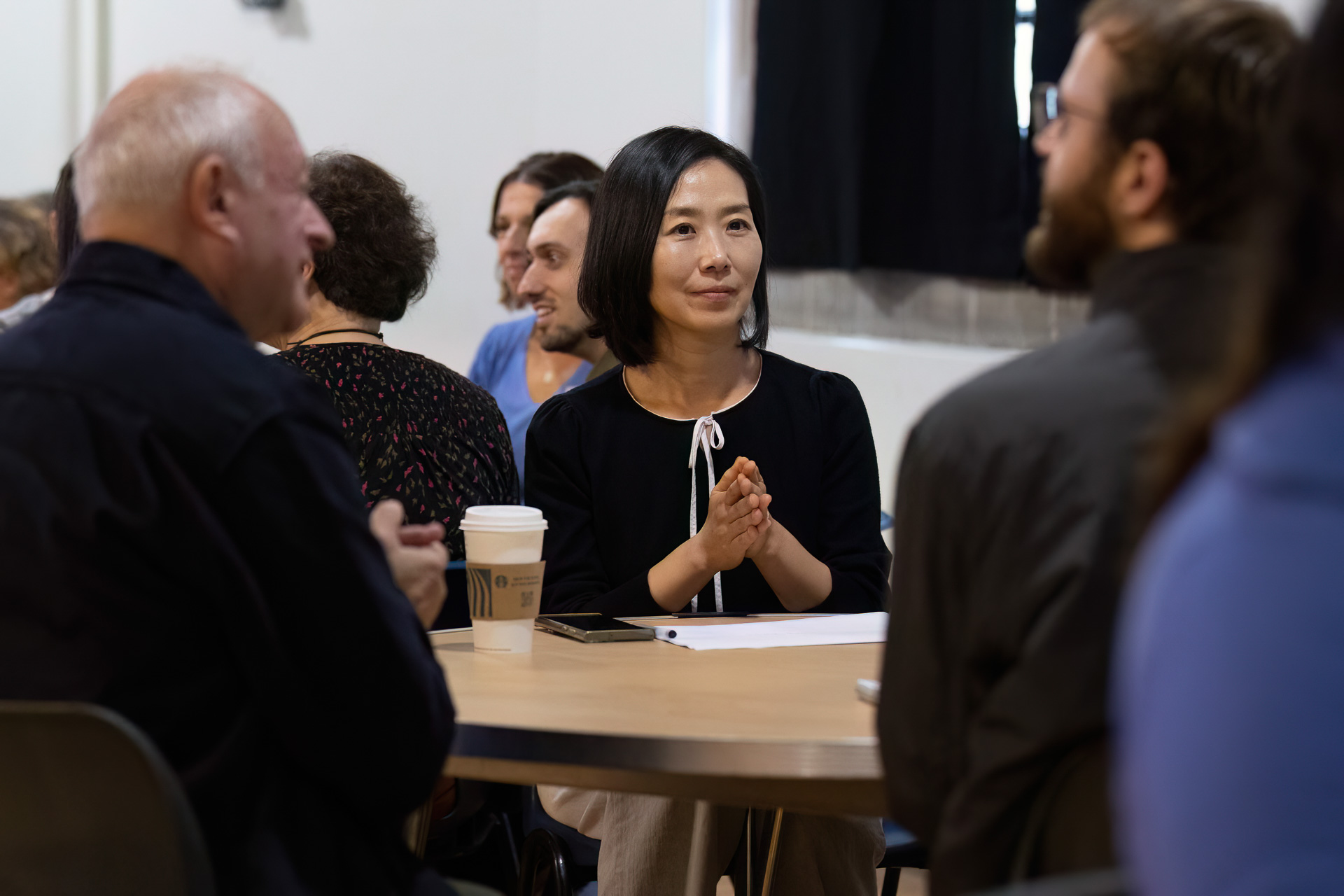 MMF tutor sitting at a table taking part in a networking or CPD session with other MMF tutors.