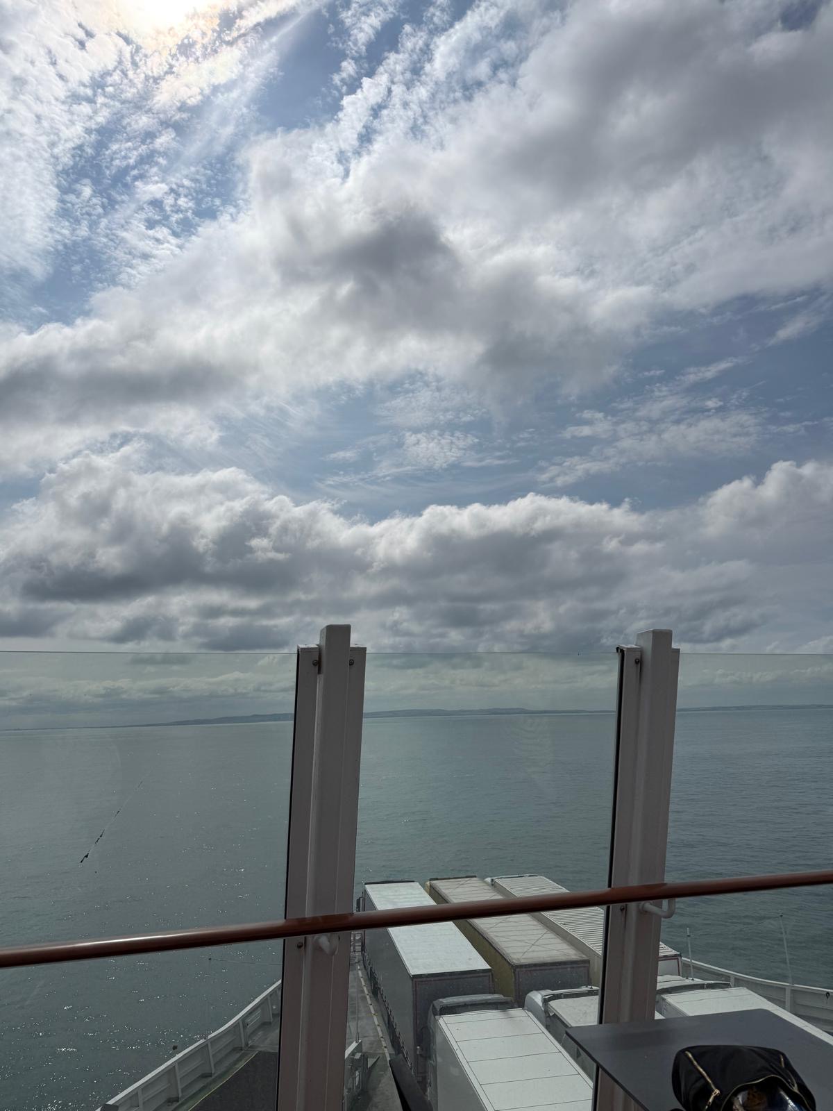 View from a ship deck overlooking the ocean under a partly cloudy sky, with several containers visible at the front of the ship, as the new TEMPO Ambassadors embark on their latest journey.