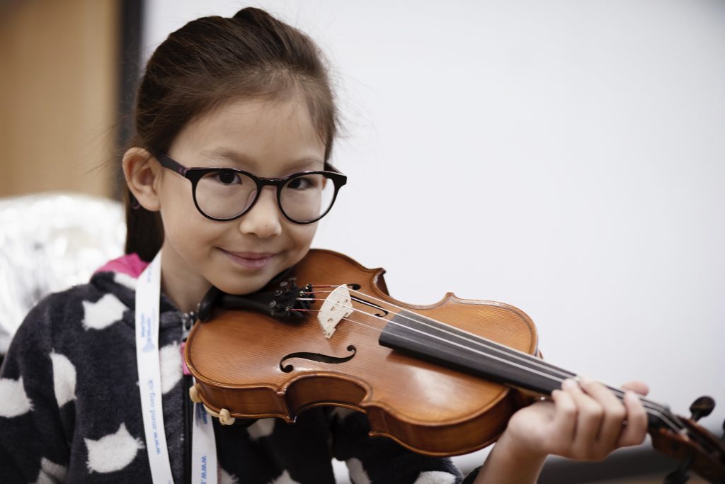 Photo of smiling girl playing violin