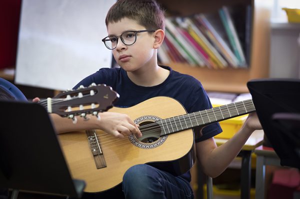 Photo of a boy playing classical guitar