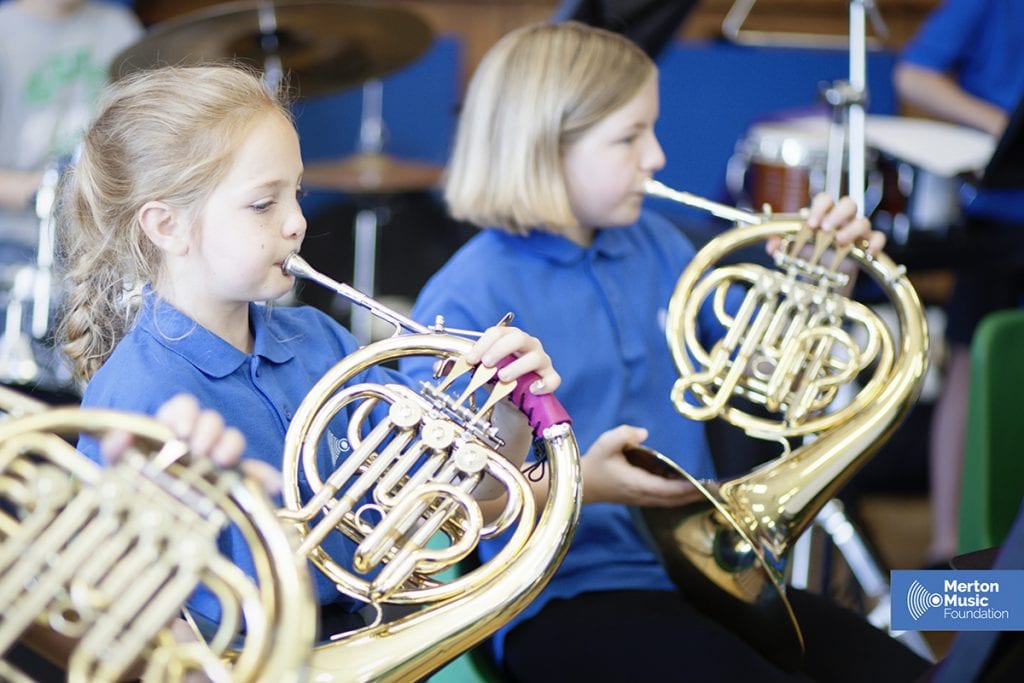 Children playing French horn in a band