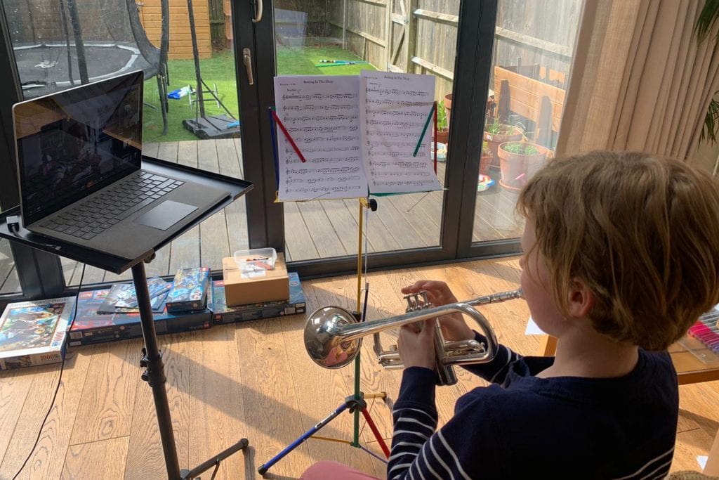 Photo of child having an online trumpet lesson at home